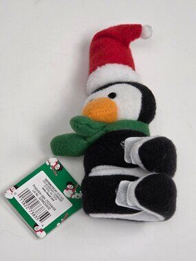 collectible plush toy of a penguin wearing a Santa hat and a green scarf